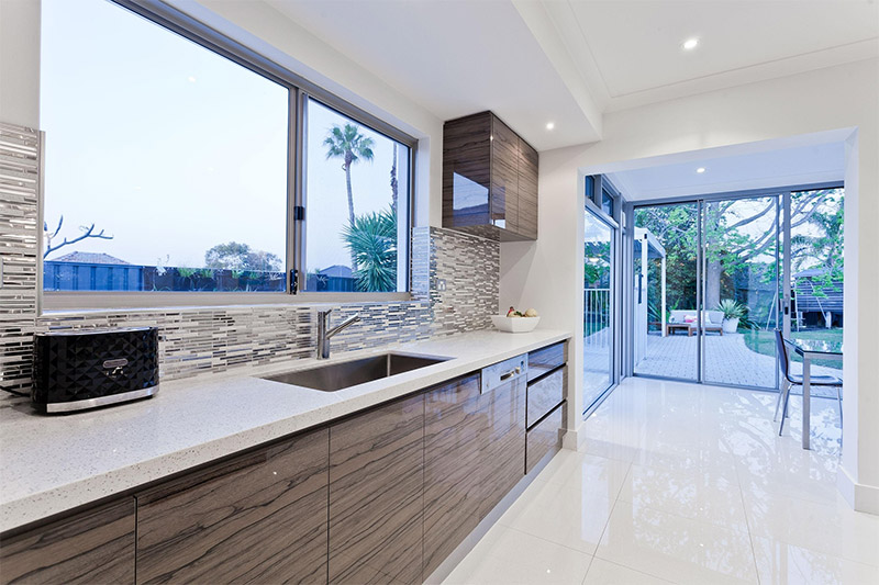 Modern kitchen sink area with a window above the counter providing natural light